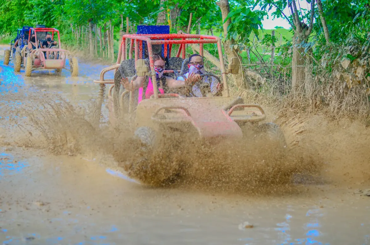 Grupo de turistas disfrutando de aventura en Buggies en excursión en Punta Cana, organizada por Aura DR Transfer