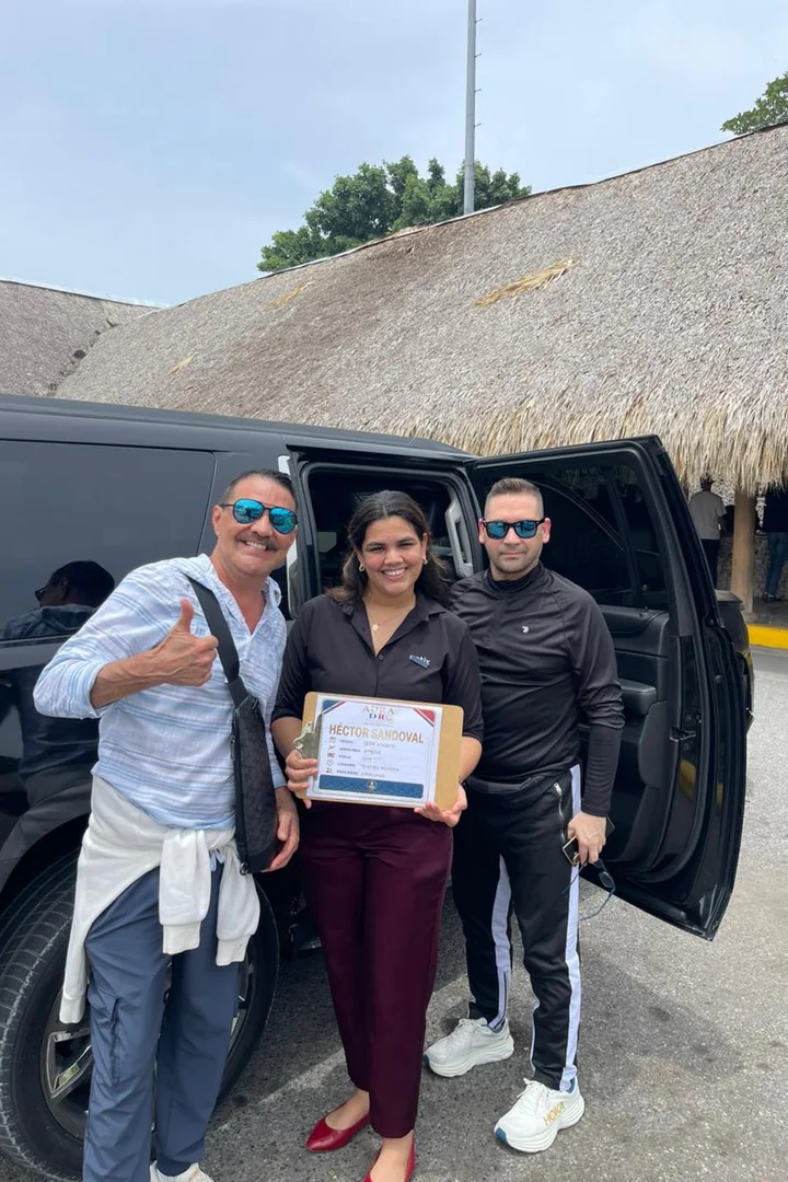 Equipo de Aura DR Transfers recibiendo a cliente con cartel nominativo para garantizar un traslado seguro y puntual en Punta Cana.